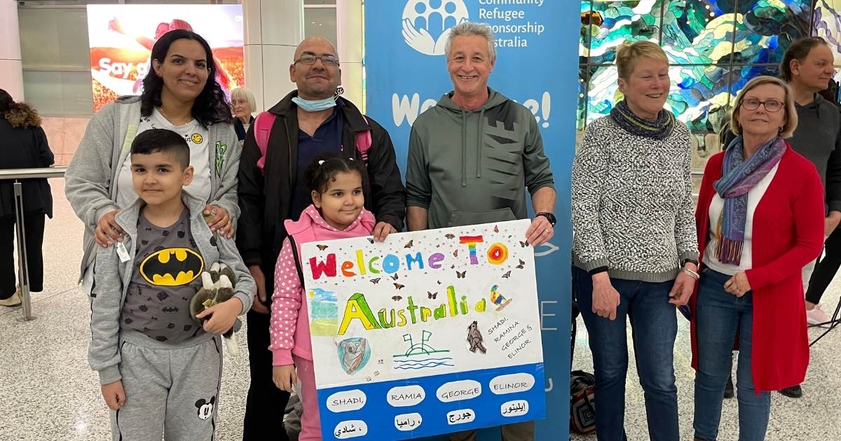 Al Daoud Family holding 'welcome to Australia' homemade sign.